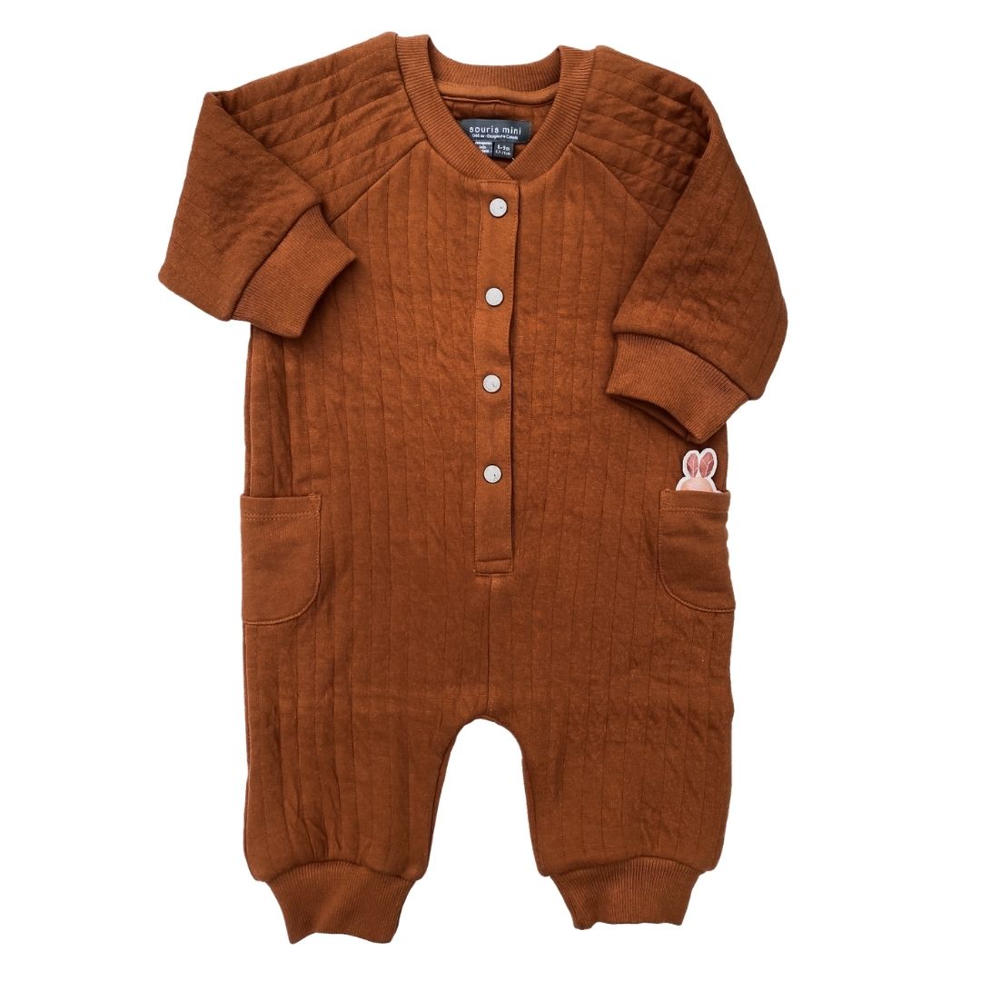 Flat lay of the Bonded Cotton Romper in Terracotta and showing the ears of the tiny bunny friend in the pocket.