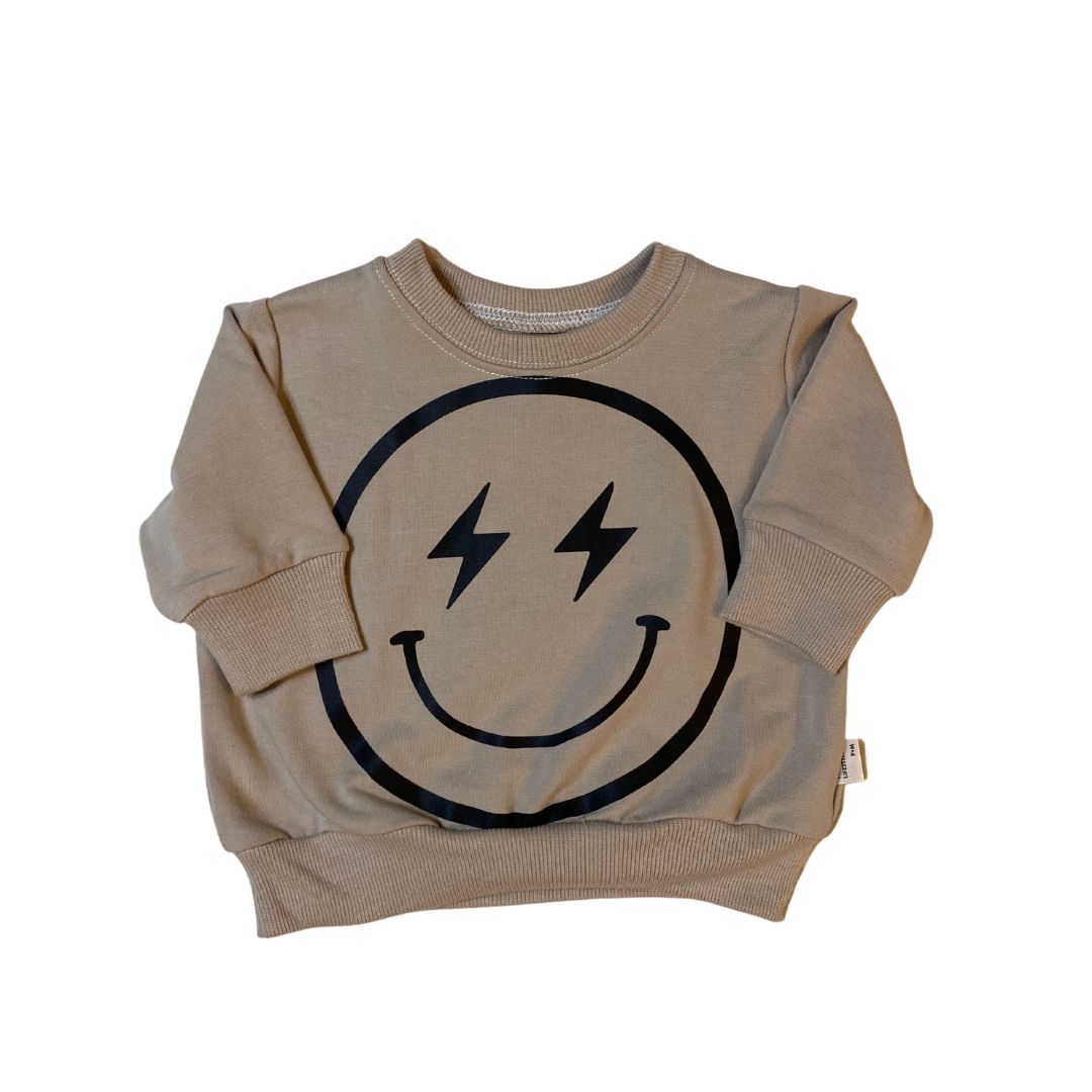 Retro fit baby and toddler sweatshirt in beige with a black happy face with lightening bolt eyes on the front.
