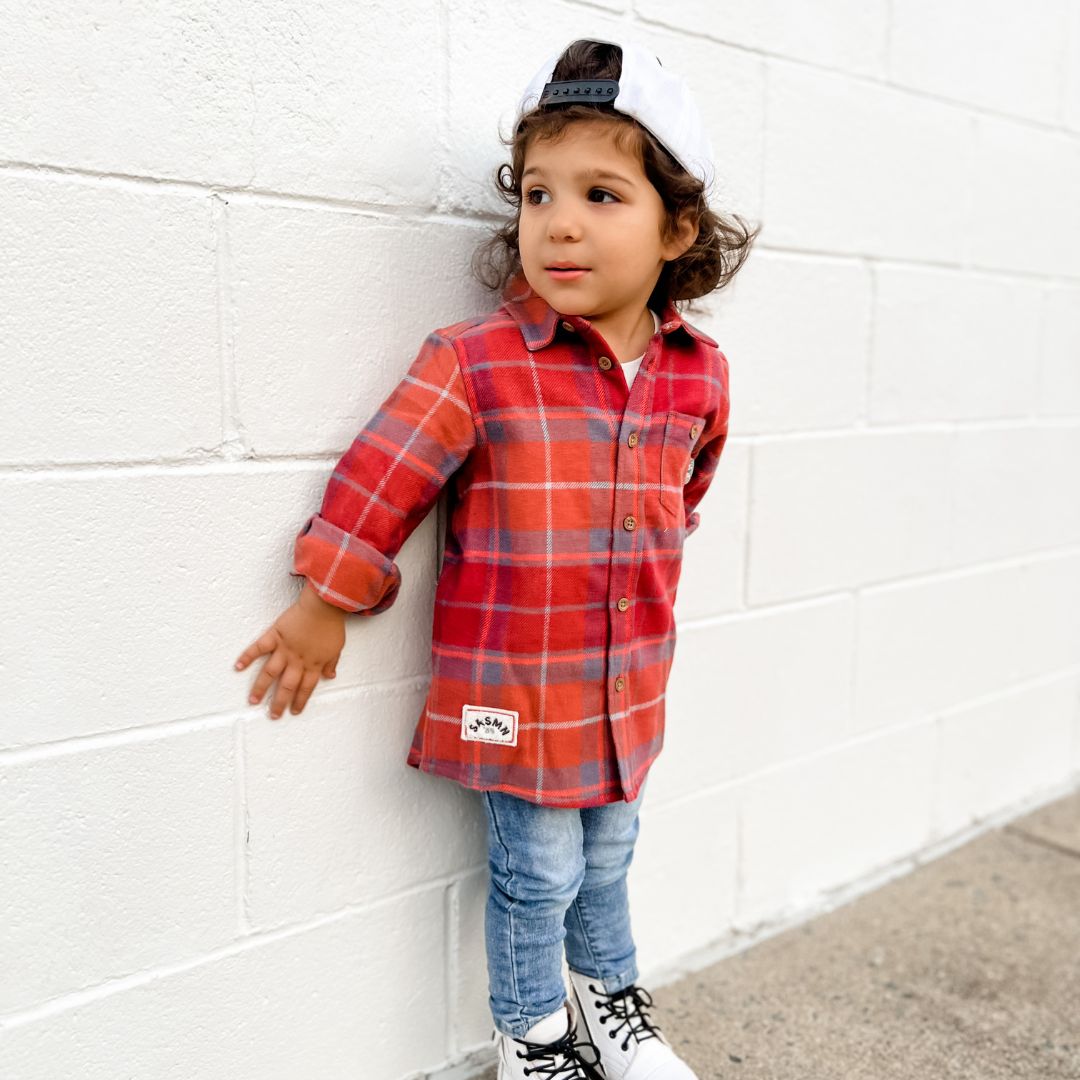 Ollie in the flannel in autumn, jeans, and white doc Martens.