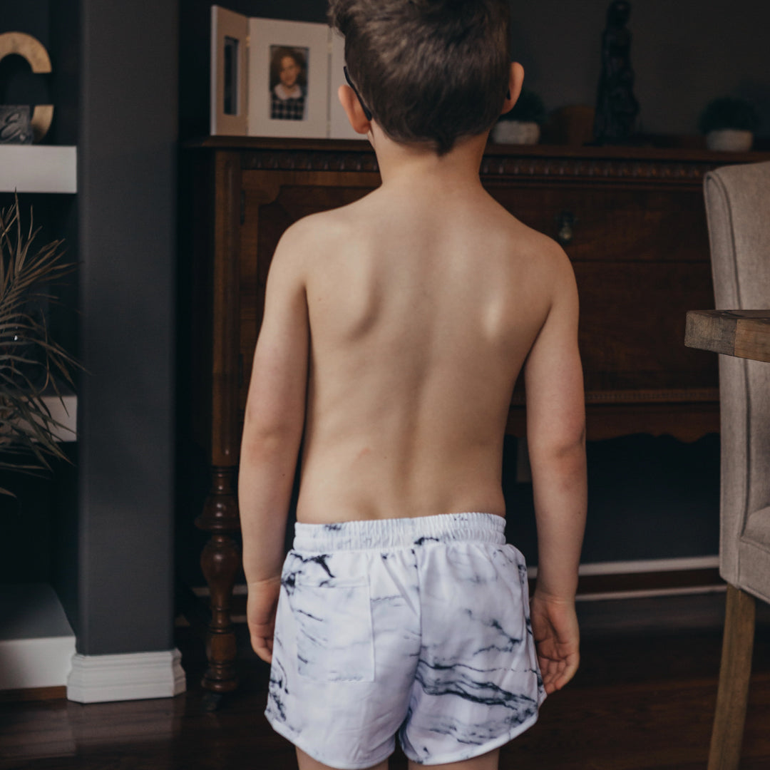 Boy looking away from the camera showing the back of the tye boardies.