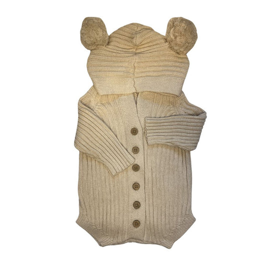 Authentic Little B's Nursery hooded knit romper in the color honey milk. Features wood like buttons down the front and pom pom "teddy bear" ears on the hood.