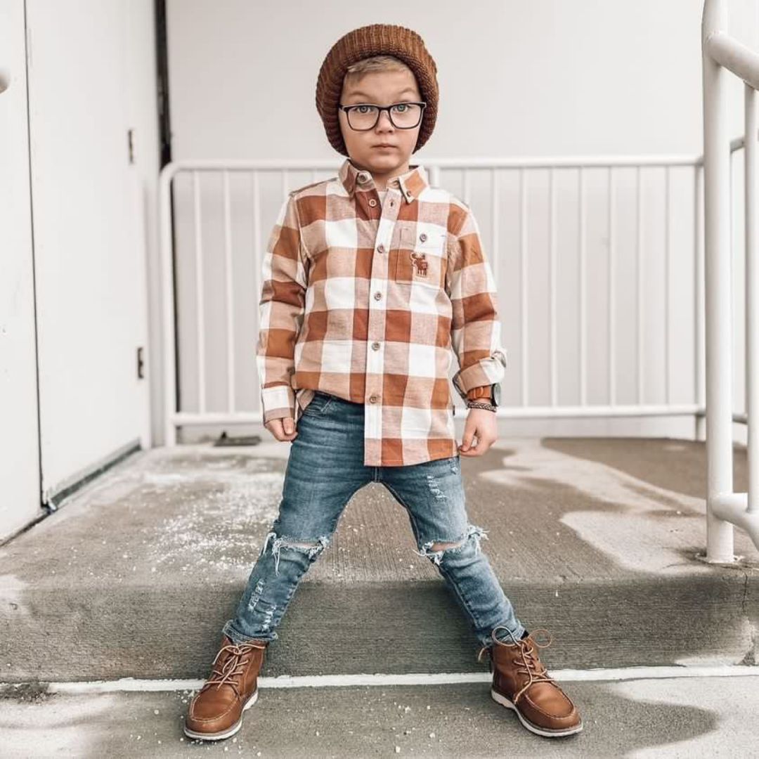 Toddler boy in a lightweight brushed flannel plaid shirt in a light brown and white called cocoa. Paired with matching brown accessories and distressed denim jeans.