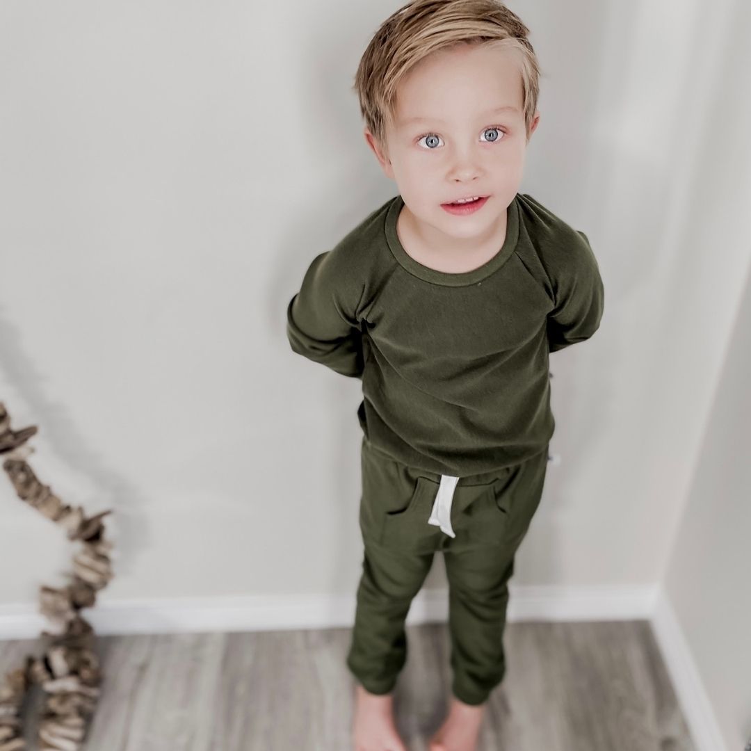 boy wearing the harem pants in forest green with the matching raglan pullover.