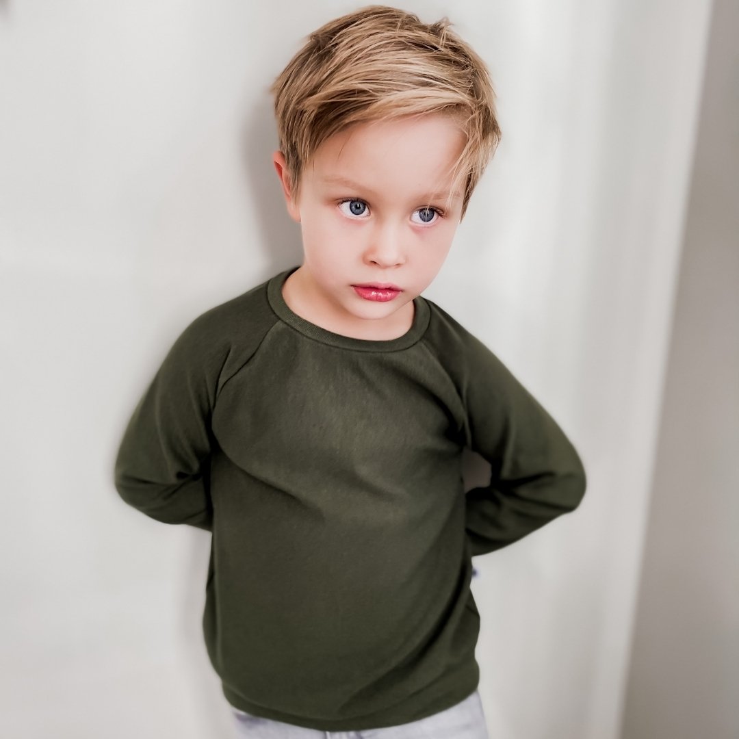 boy wearing the raglan pullover in forest green.