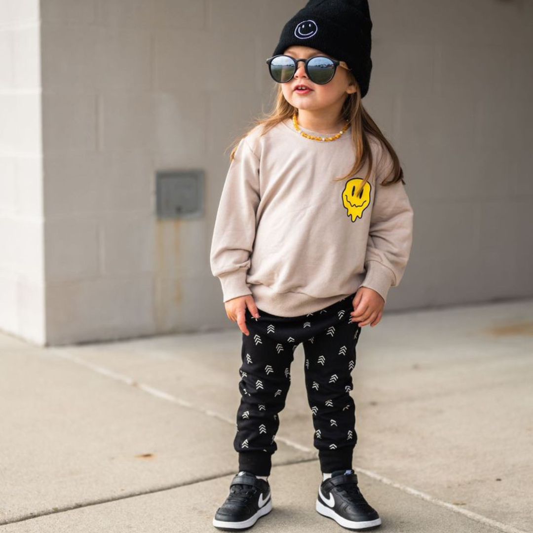 Keegan in the "have a good day" sweatshirt, arrow joggers, black high-ups, and a black beanie.