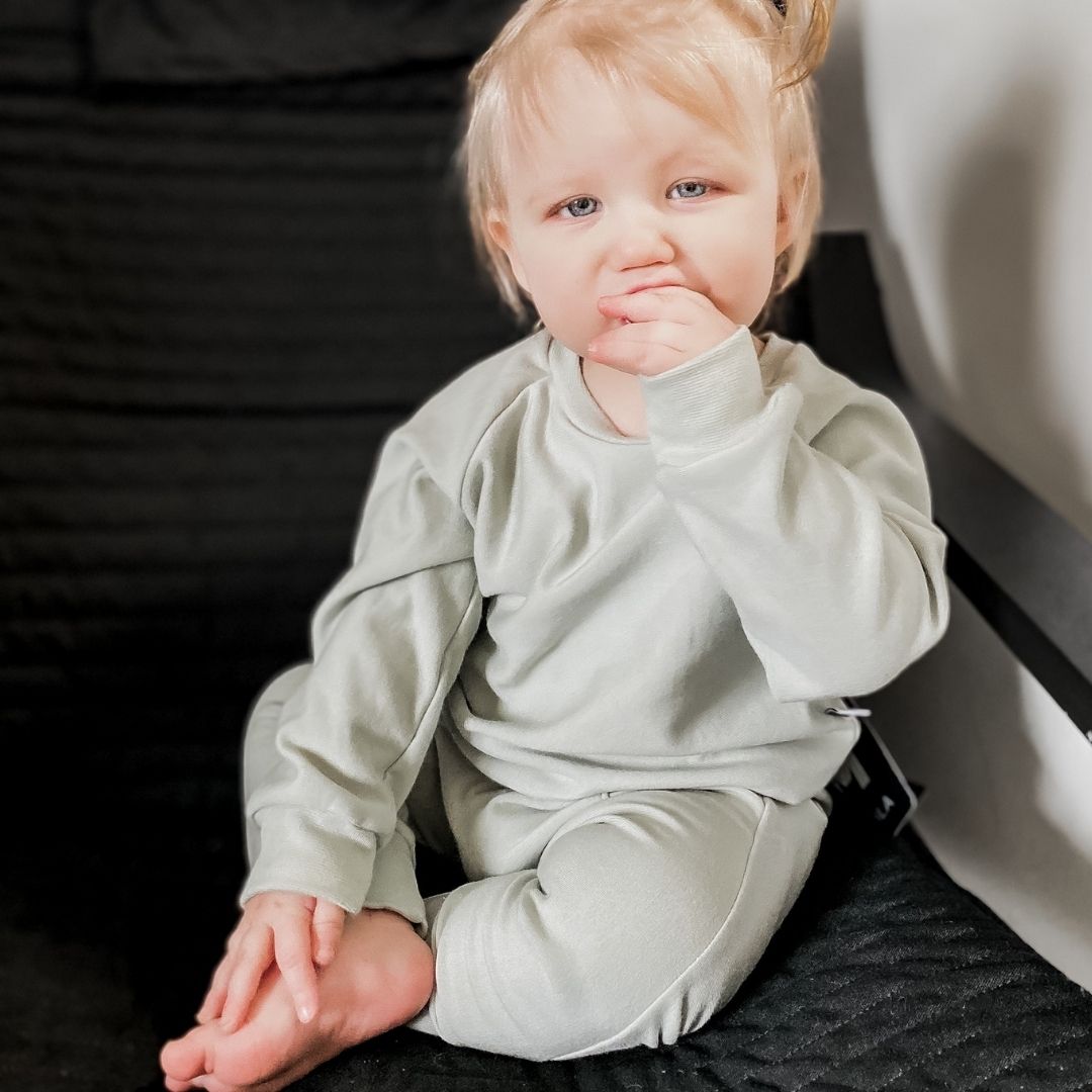 Baby girl wearing the harem pants in mint green and the matching raglan pullover
