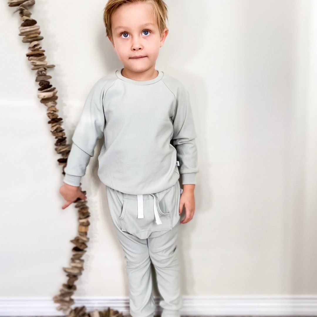 boy wearing the harem pants in mint green and the matching raglan pullover