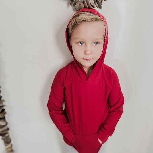 four year old blonde boy wearing the hooded raglan pullover sweater in cherry red.