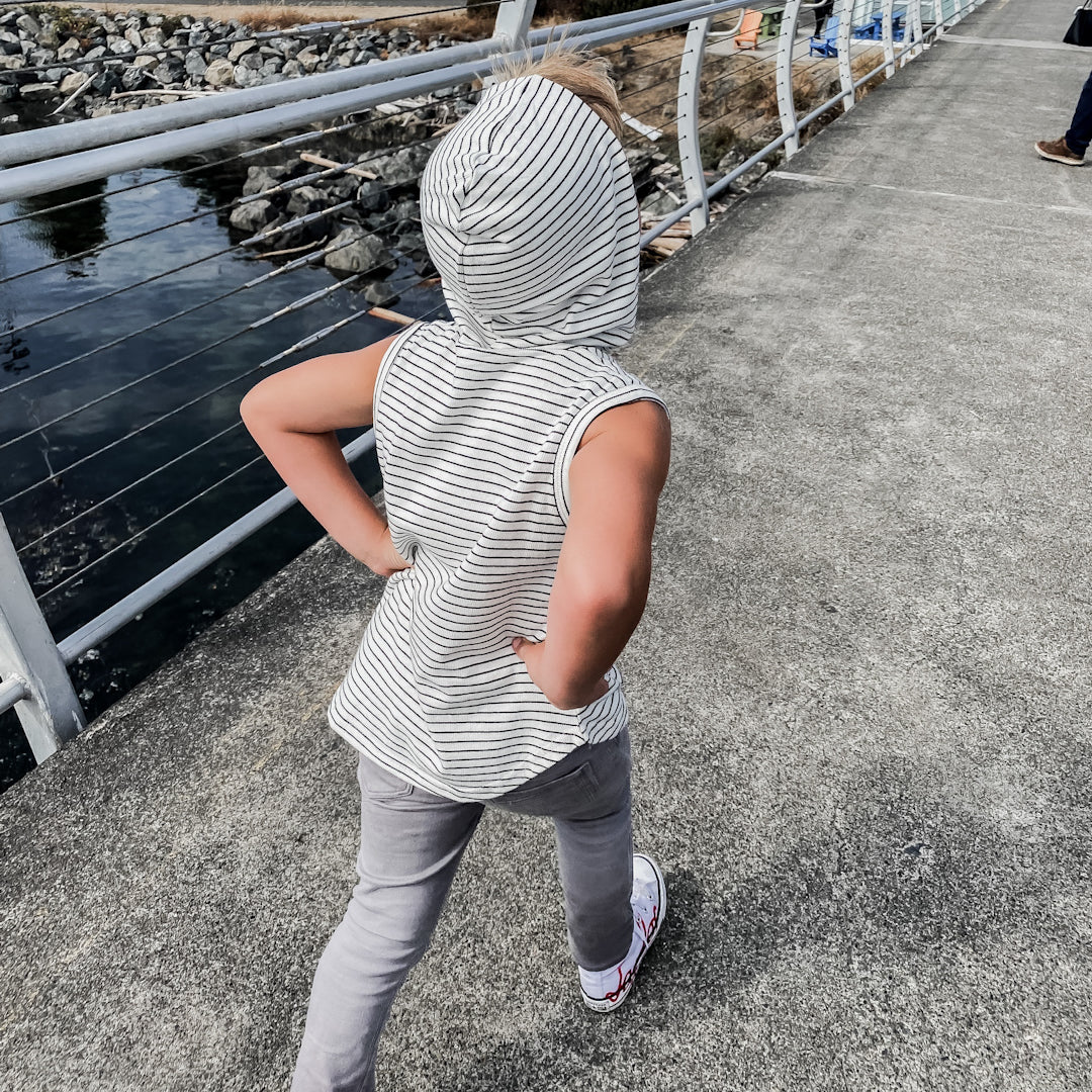 Boy wearing the rib knit sleeveless hoodie in black and white stripes