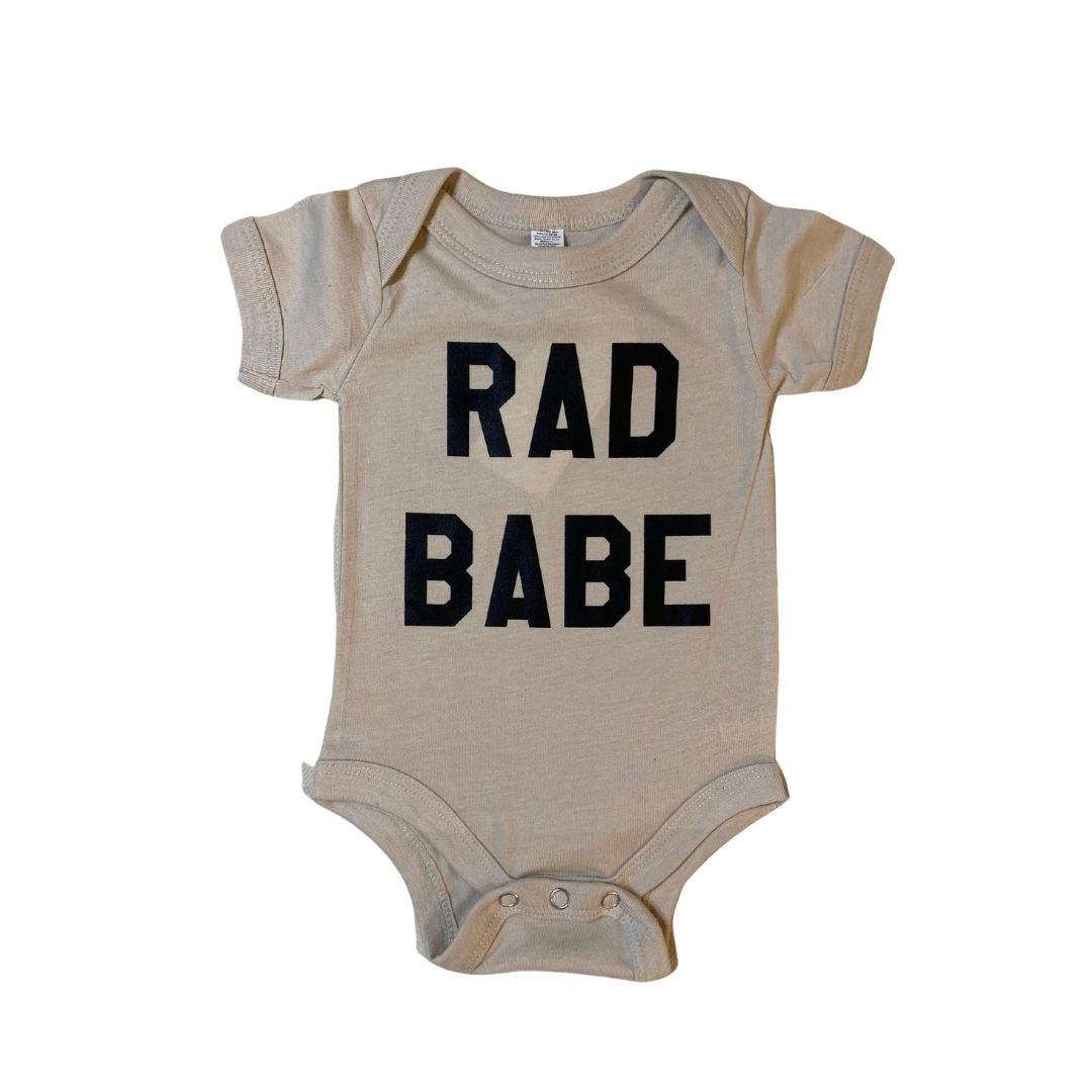 Slim cut bodysuit for babies ages 0 - 24 months with "rad babe" written in old school lettering on the front.