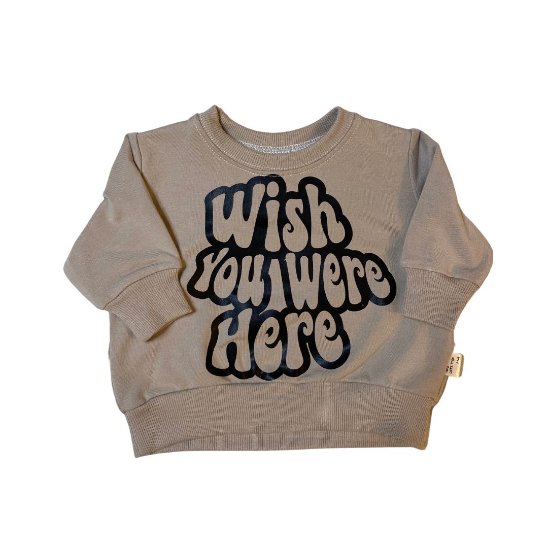Retro fit sweatshirt in beige with "wish you were here" written in a black font on front.