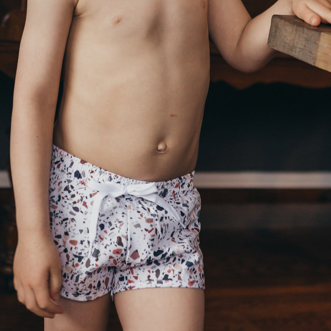 Close up of the Blake boardies which have a neutral terracotta print on a white background